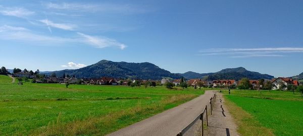 Road amidst field against sky