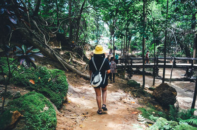 Full length of woman walking on footpath in forest