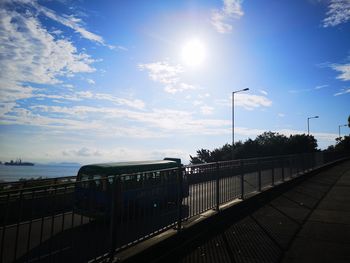 Street by sea against sky on sunny day