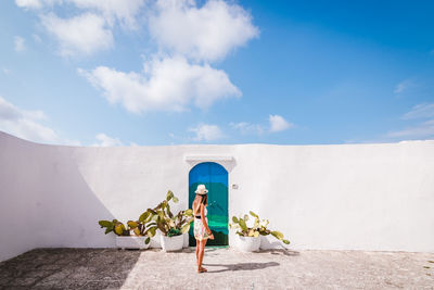 Rear view of woman standing against blue sky