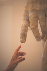 Close-up of hand holding ice cream against wall