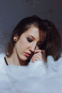 Close-up of young woman against wall