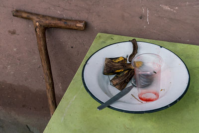 High angle view of cane and used dining utensils on table