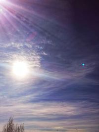 Low angle view of bright sun in sky