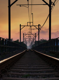 Railroad tracks against sky during sunset