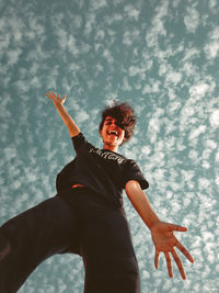 Low angle view of woman standing against sky