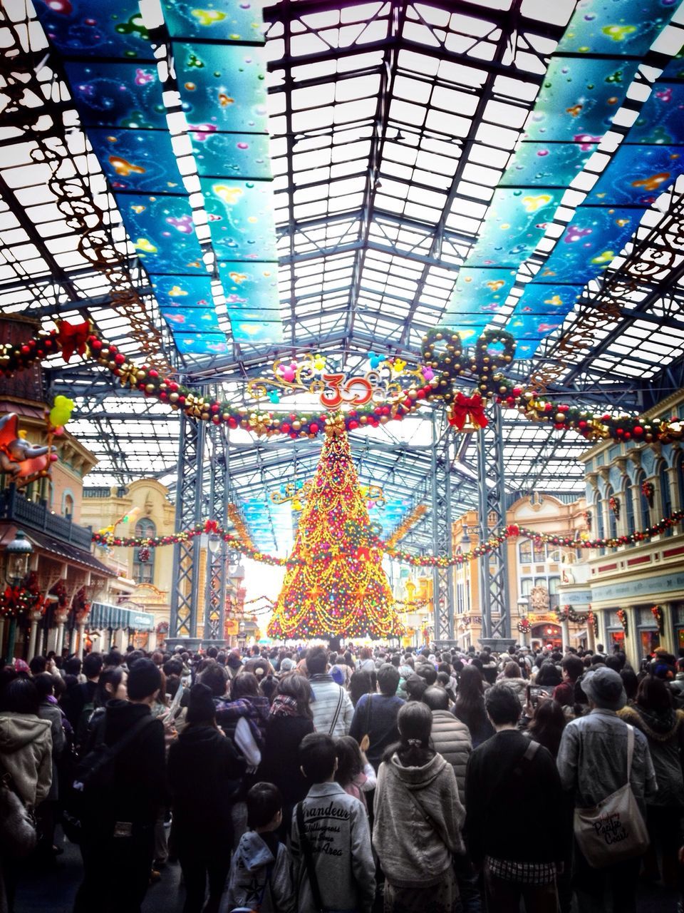 large group of people, crowd, indoors, men, architecture, built structure, illuminated, person, lifestyles, lighting equipment, city life, ceiling, leisure activity, shopping mall, city, building exterior, railroad station, public transportation, street