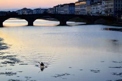 Bridge over river in city against sky