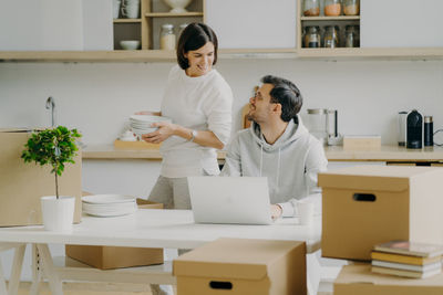 Couple with cardboard boxes at new home