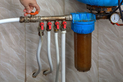 Cropped hand of man working with pipes and valve