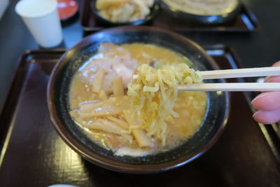 Close-up of hand holding soup in bowl