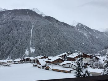 Houses on snowcapped mountain against sky