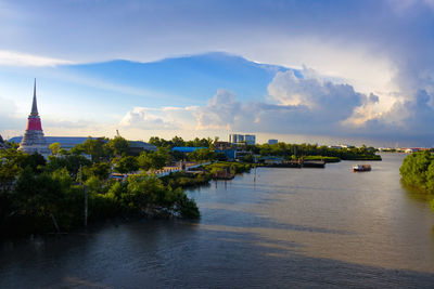 Scenic view of river by buildings against sky