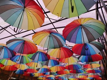 Low angle view of multi colored umbrellas hanging against ceiling