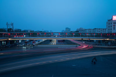 Light trails on road against clear sky at night