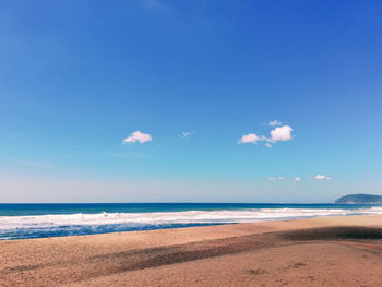 Scenic view of beach against blue sky