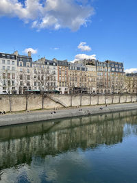 Arch bridge over river against buildings in city