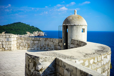 Built structure by sea against sky