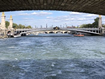 Arch bridge over river against sky