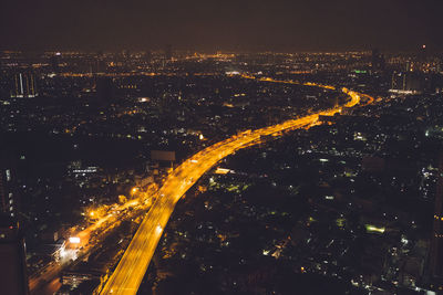 Aerial view of illuminated bridge amidst cityscape at night