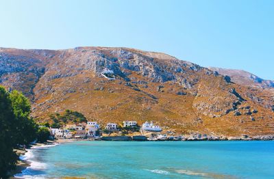 Scenic view of sea against clear sky with mountains in the background 