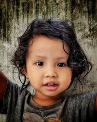 Portrait of cute girl against wall