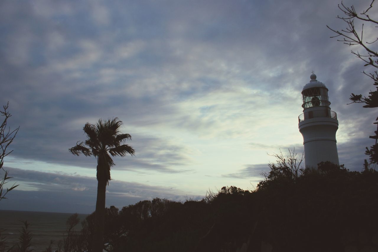 SILHOUETTE OF PALM TREES AND LIGHTHOUSE AGAINST SKY