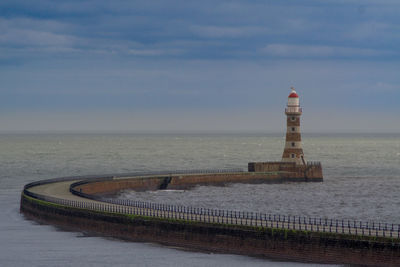 Scenic view of lighthouse by sea against sky