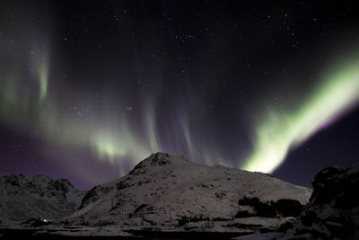 Scenic view of snowcapped mountains against sky at night