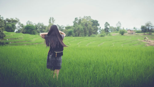 Rear view of woman standing in field