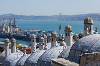 High angle view of city by sea against clear sky