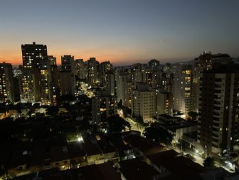 Illuminated cityscape against sky at night