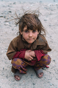 Portrait of boy wearing traditional clothing crouching