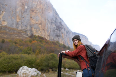 Rear view of woman sitting on rock