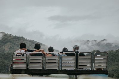 Rear view of friends on seat against mountains