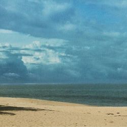 Scenic view of sea against cloudy sky