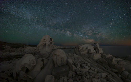 Rock formations against sky at night