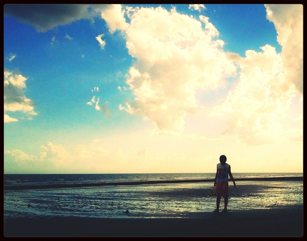 SILHOUETTE GIRL STANDING AT BEACH AGAINST SKY