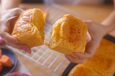 High angle view of woman holding bread on table