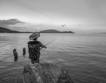 Rear view of man fishing in sea