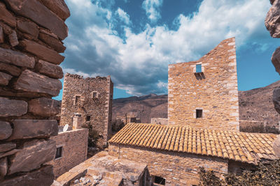 Low angle view of old ruins of greek village against sky