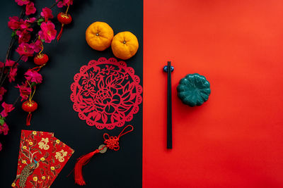 Chinese lunar new year decoration over red and black background. flat lay dinning table concept.