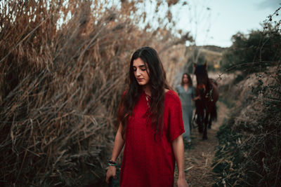 Portrait of beautiful young woman standing on land