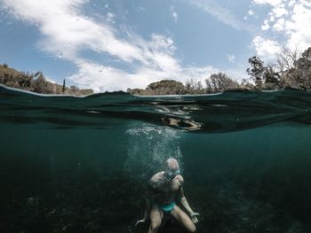 Rear view of woman swimming in sea