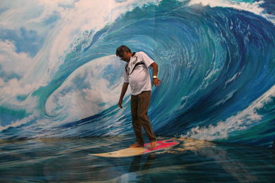 Side view of young man standing in sea