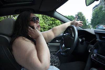 Midsection of woman sitting in car