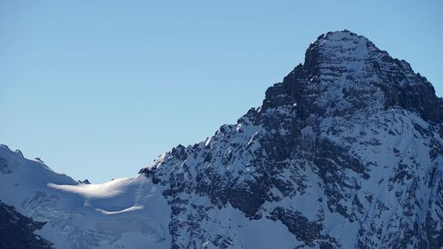 Scenic view of snowcapped mountains against clear blue sky