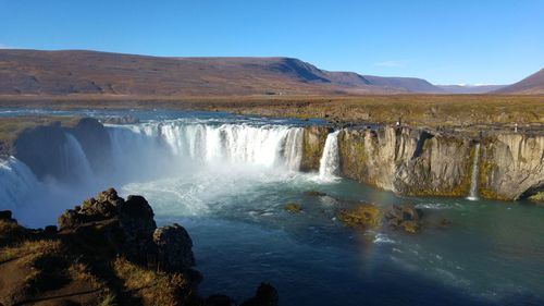 Scenic view of waterfall against clear sky