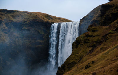 Scenic view of waterfall against sky