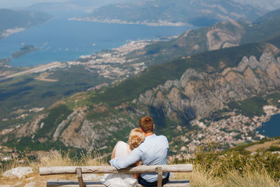 People sitting on bench at mountain